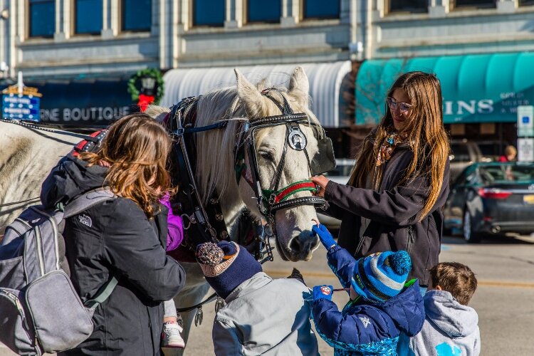 With a little help, children pet the horses during the 2022 Sundays in the City celebration.