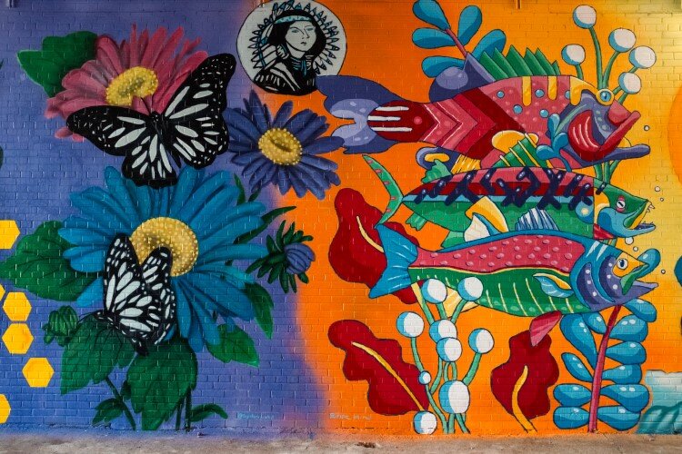 In the United We go mural in an alley, the illustrations flow from one artist's work to another.