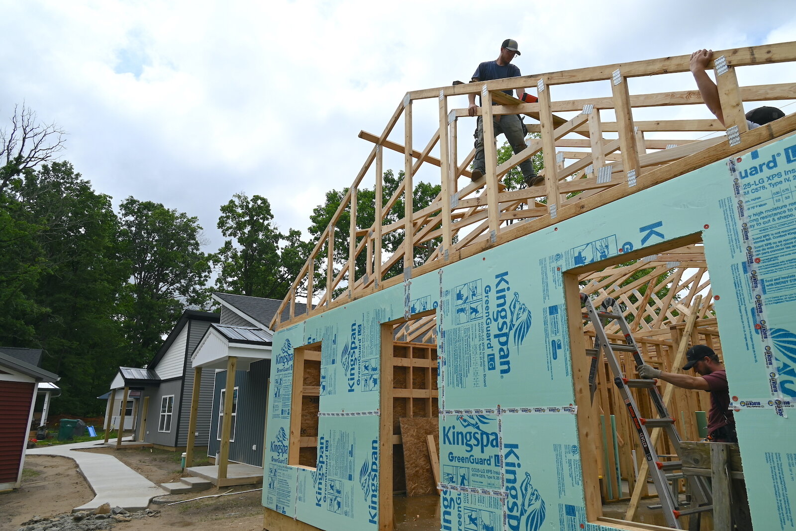 Workers build the frame for the roof for a house in Eaton Village.